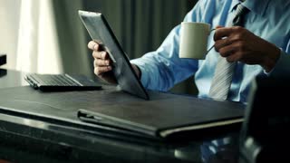 businessman-reading-something-on-tablet-computer-by-desk-at-office_vy33h47lg__S0000